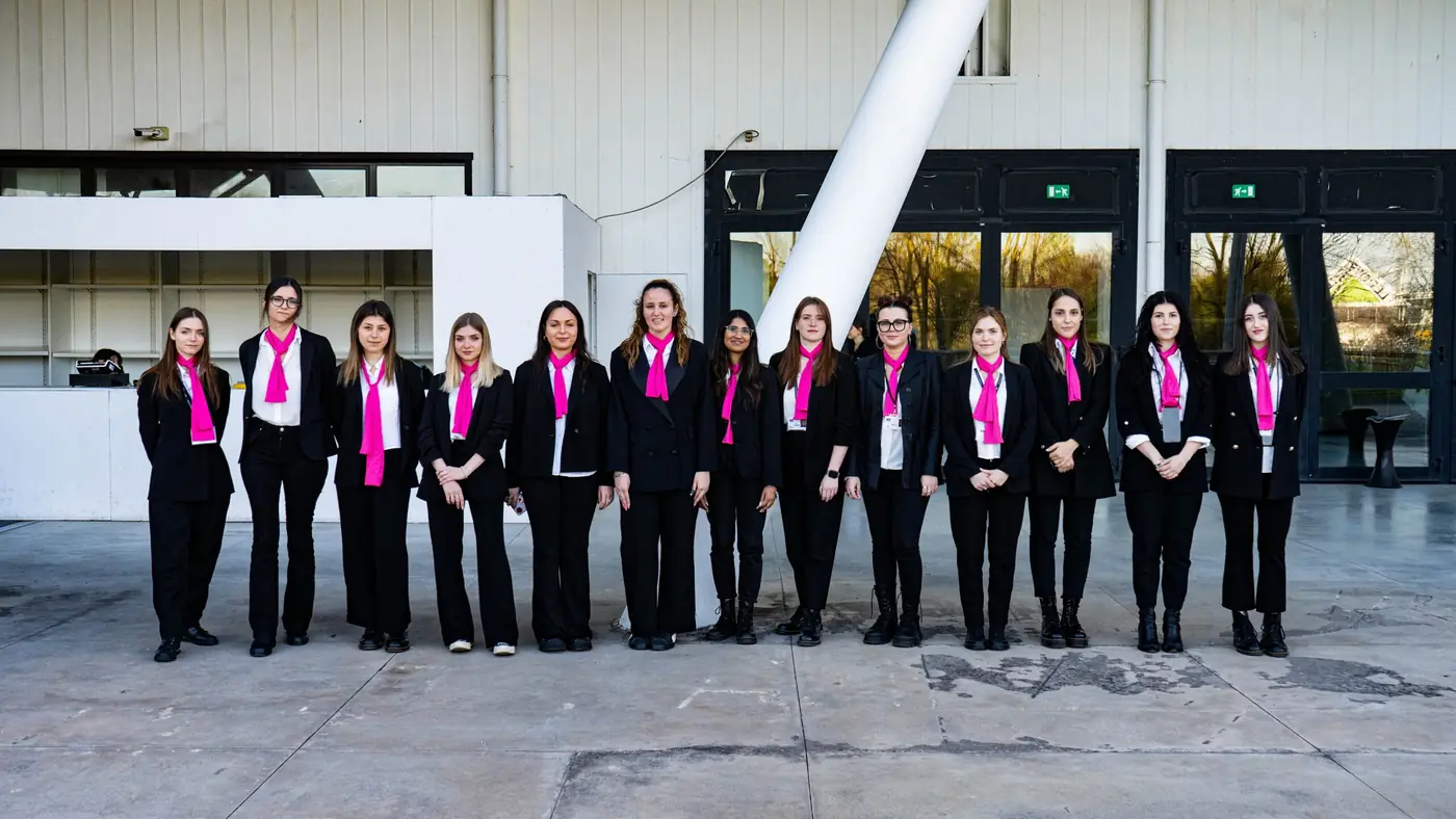 Le hostess YES in divisa nera e foulard fucsia schierate all'ingresso di un evento