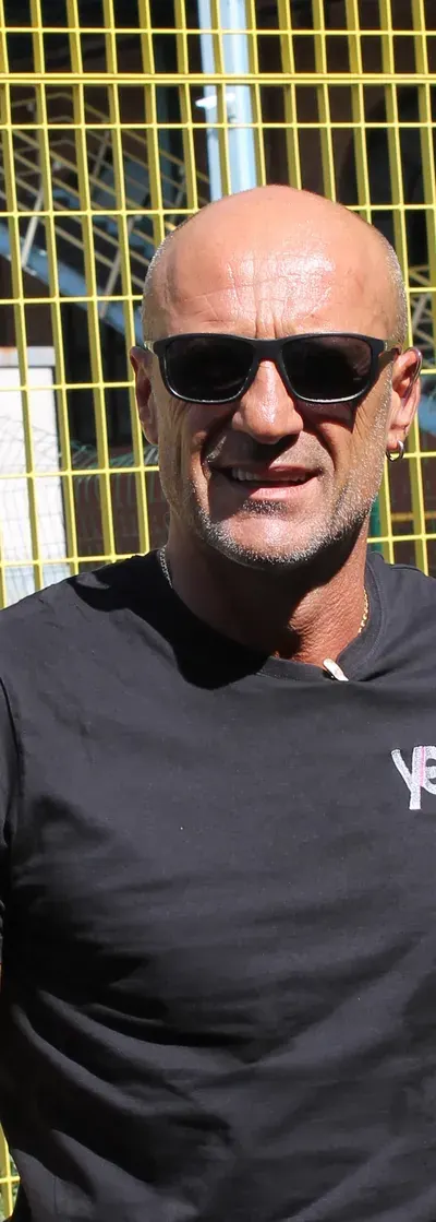 Operatore YES con occhiali da sole e maglia aziendale sorride vicino ai varchi