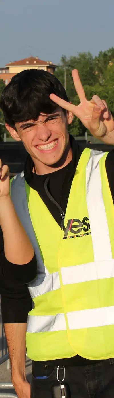 Steward YES in gilet alta visibilità sorride e fa il segno della pace